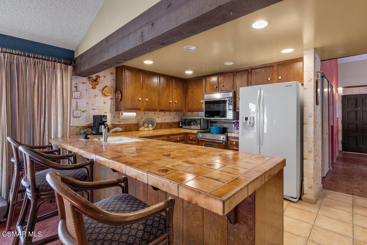2268 Pinecrest Street Simi Valley, CA 93065 - Photo 9 of 28 a kitchen with stainless steel appliances granite countertop a sink a stove and a refrigerator