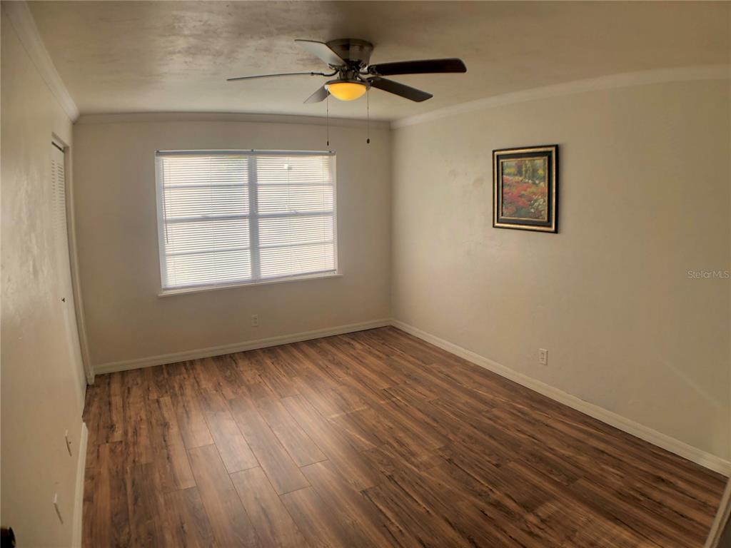 5403 Northwest 20th Court, Unit C Gainesville, FL 32653 - Photo 10 of 21 a view of an empty room with a window and wooden floor