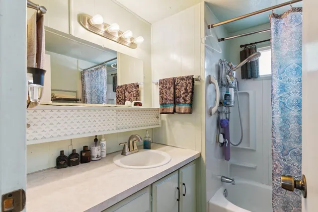 a bathroom with a granite countertop sink a toilet and shower
