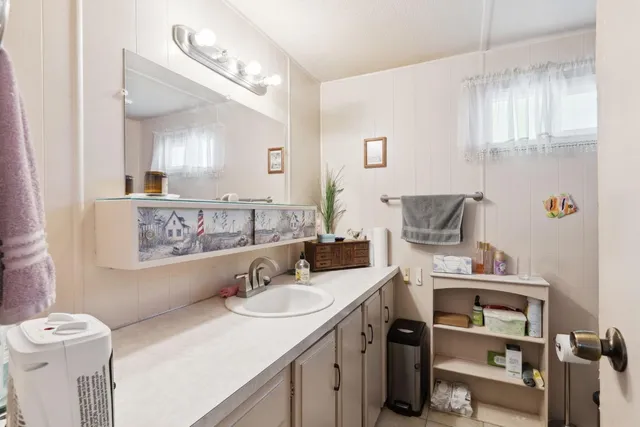a bathroom with a double vanity sink toilet and a mirror
