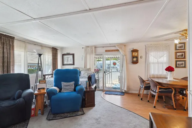 a living room with furniture ceiling fan and a window