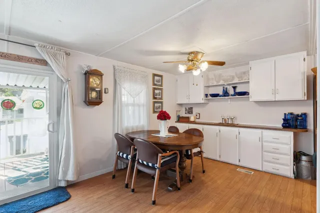 a kitchen with stainless steel appliances a dining table chairs and wooden floor