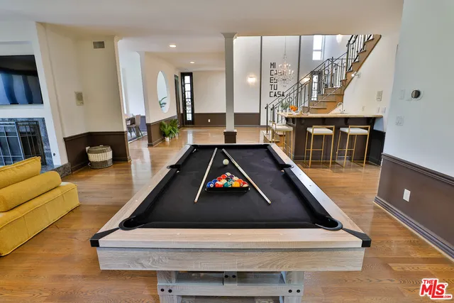 a living room with furniture pool table and a large window