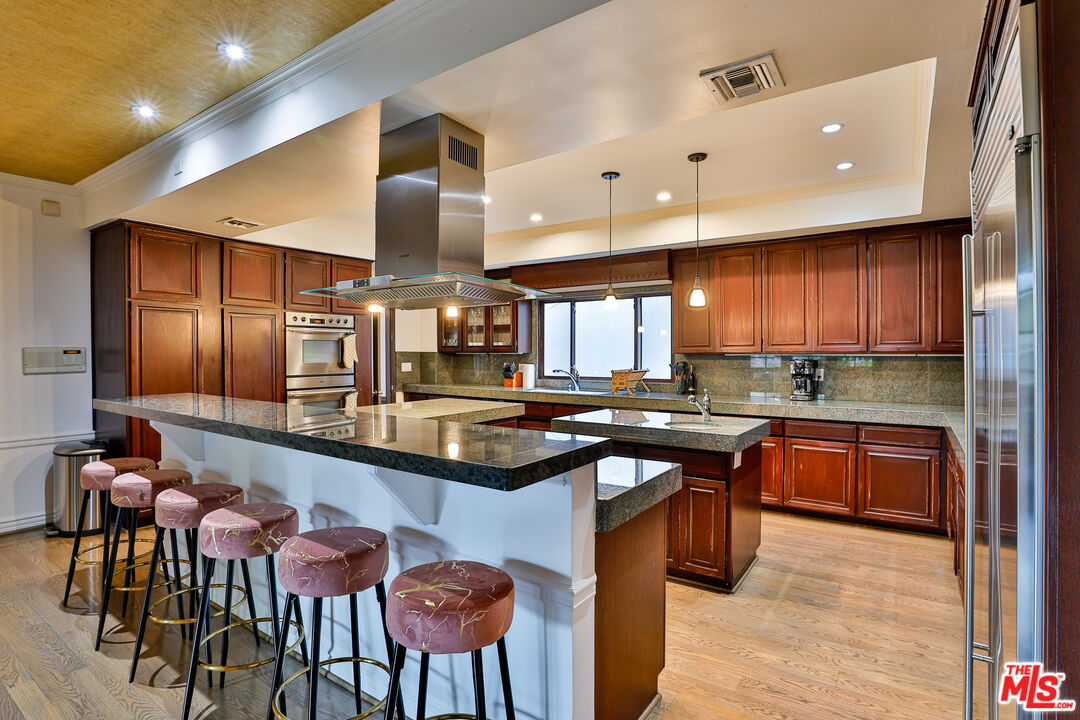 14839 Valley Vista Boulevard Sherman Oaks, CA 91403 - Photo 3 of 65 a kitchen with stainless steel appliances granite countertop counter space a sink and chairs