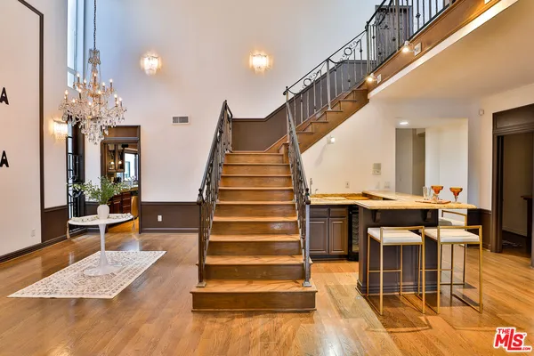 a bedroom with a large bed and wooden floor