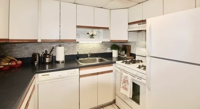 a kitchen with stainless steel appliances white cabinets and a refrigerator