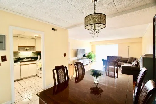 a living room with stainless steel appliances furniture a dining table and chairs