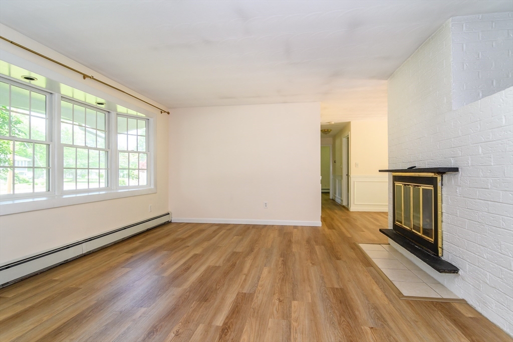 33 Eisenhower Road Framingham, MA 01701 - Photo 4 of 20 a view of an empty room with a window and wooden floor