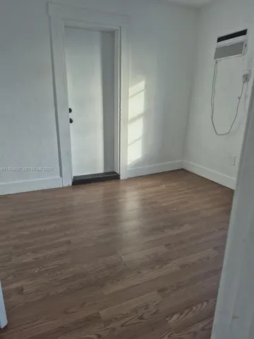 a view of a room with wooden floor and cabinet