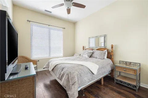 a bedroom with a bed and a flat tv screen on dresser