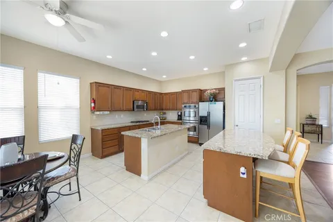 a large kitchen with kitchen island granite countertop lots of counter space a sink appliances and a dining table