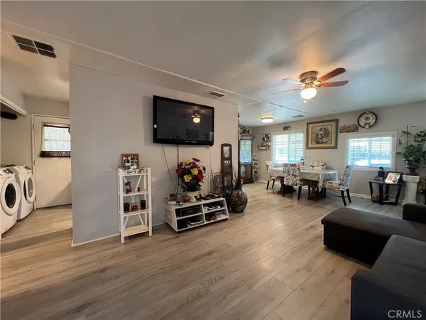 a living room with furniture a flat screen tv and kitchen view