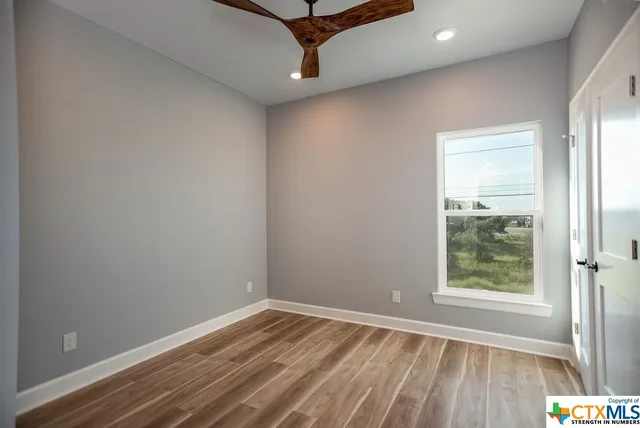 a view of empty room with wooden floor
