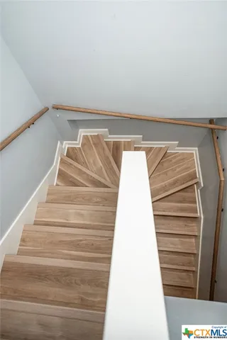 a bedroom with a bed and a chair with the wooden floor