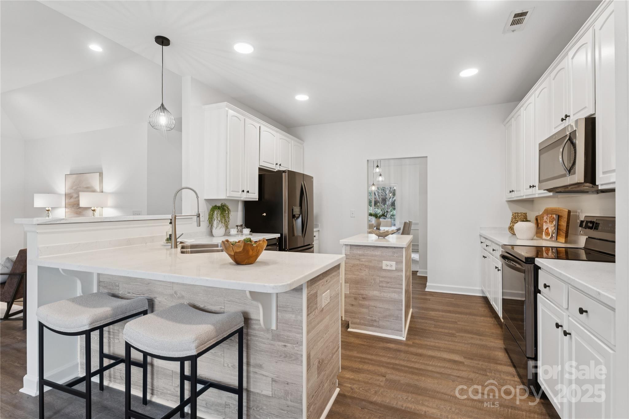 312 Albany Street Fort Mill, SC 29715 - Photo 10 of 36 a kitchen with stainless steel appliances granite countertop a sink a stove a refrigerator and a dining table with wooden floor