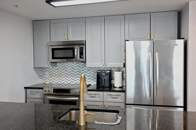 a kitchen with stainless steel appliances a refrigerator a stove a microwave and cabinets