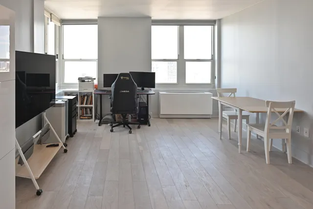a view of a workspace with furniture and a window