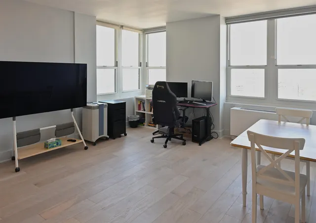 a view of a workspace with furniture and a window