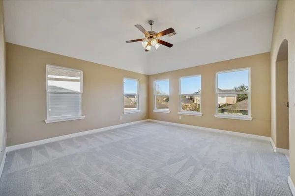 an empty room with windows and fan