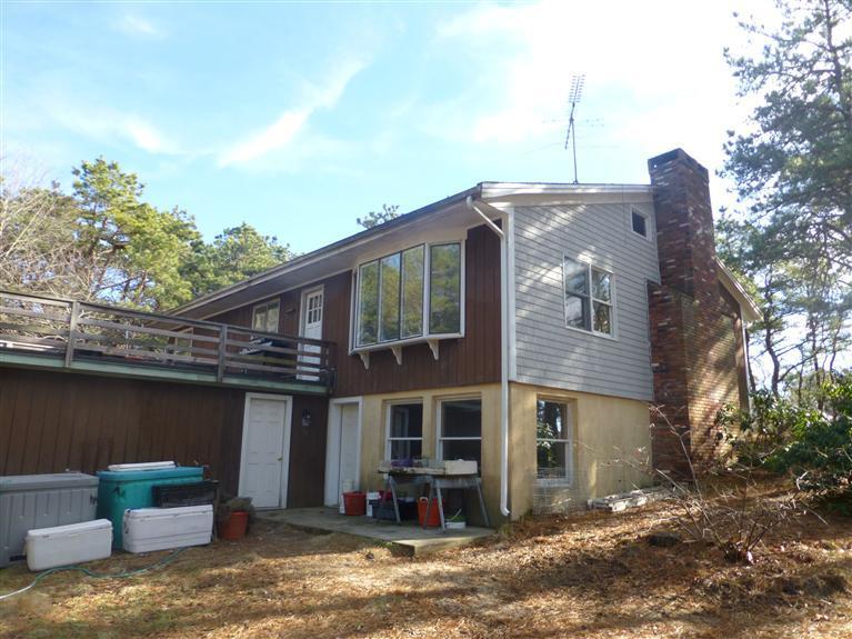 335 Cove View Road Wellfleet, MA 02667 - Photo 3 of 25 a front view of a house with a yard