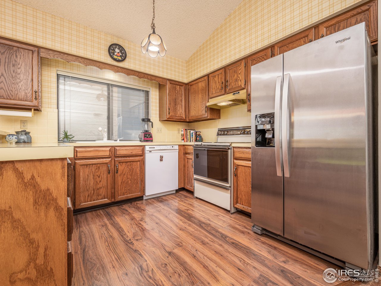 314 Eagle Court Longmont, CO 80504 - Photo 17 of 40 a kitchen with stainless steel appliances granite countertop a refrigerator a sink a stove and white cabinets with wooden floor