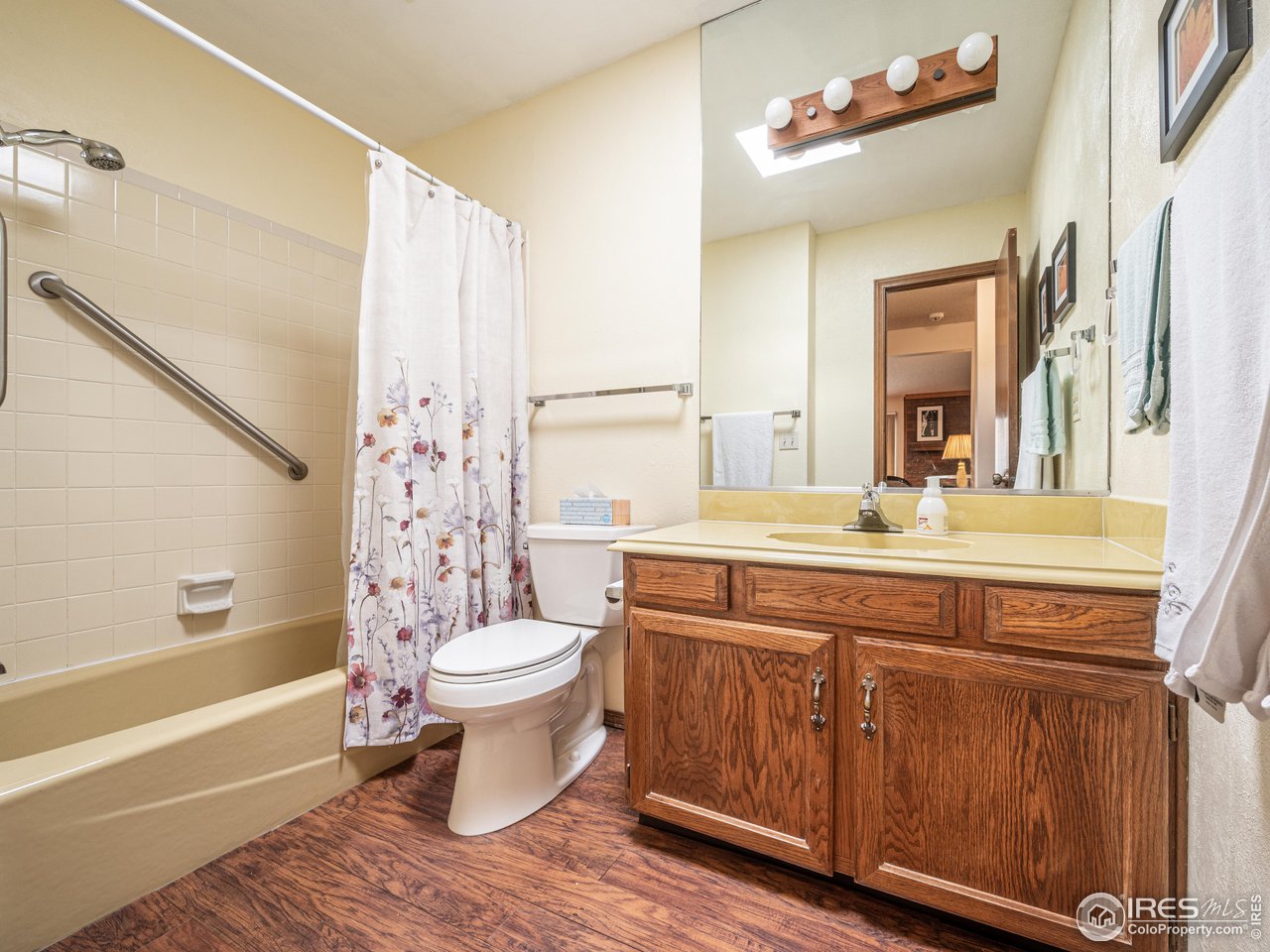 314 Eagle Court Longmont, CO 80504 - Photo 30 of 40 a bathroom with a sink a toilet a mirror a vanity and bathtub