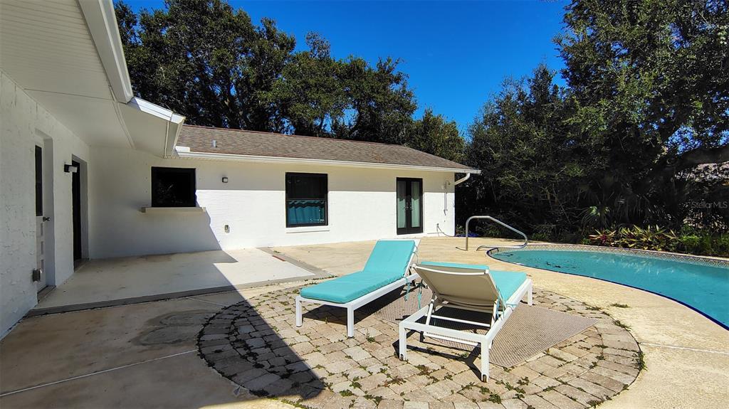 4790 Michael Lane Ponce Inlet, FL 32127 - Photo 25 of 35 a view of a patio with a table and chairs under an umbrella