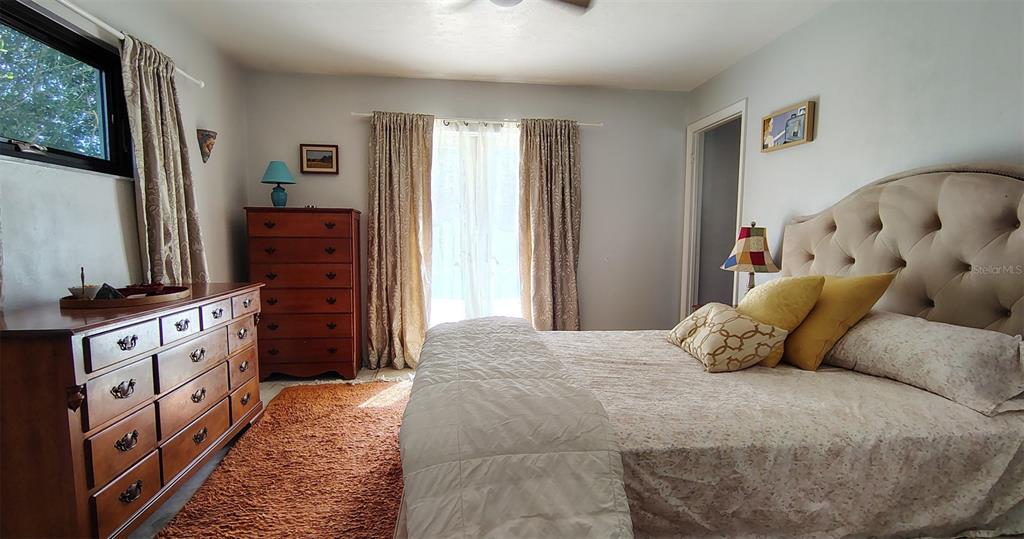 4790 Michael Lane Ponce Inlet, FL 32127 - Photo 10 of 35 a bedroom with a bed dresser and a flat tv screen