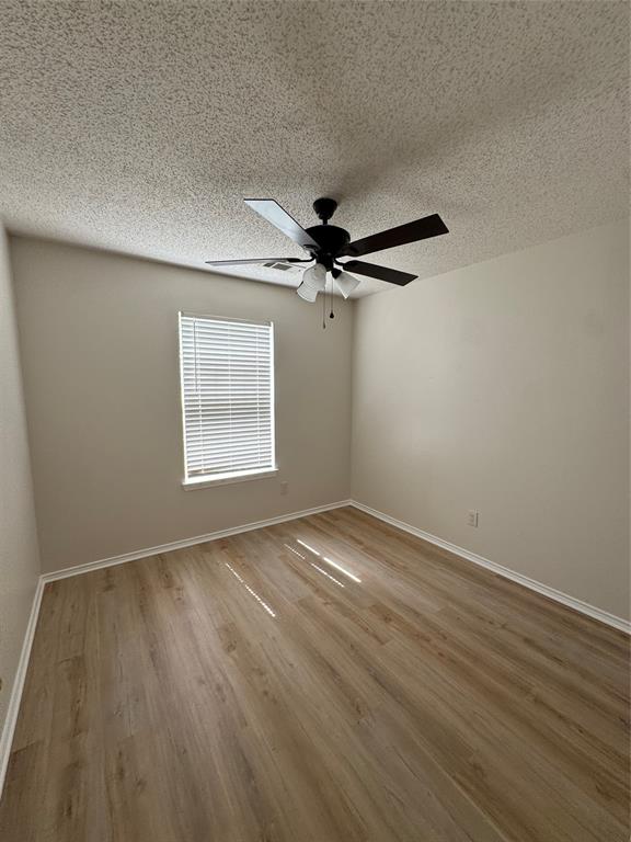 1109 North Riggins Street Anna, TX 75409 - Photo 7 of 11 an empty room with wooden floor fan and windows