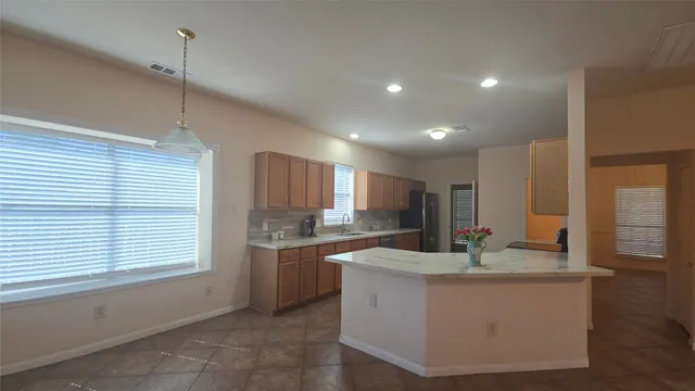 a kitchen with kitchen island sink cabinets and window