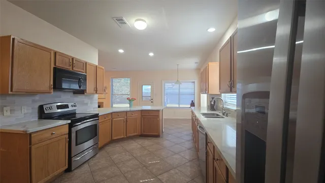 a kitchen with stainless steel appliances granite countertop a refrigerator and a stove top oven