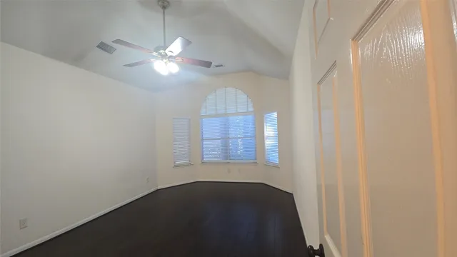 en empty room with windows and fan