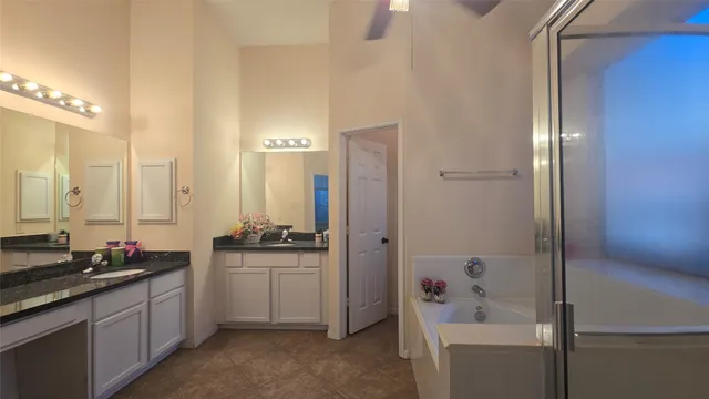 a bathroom with a double vanity sink a mirror a bathtub and shower