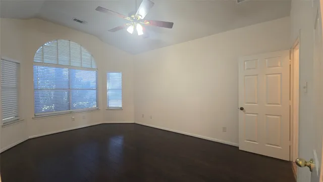 an empty room with a window and wooden floor