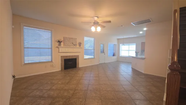 a view of a livingroom with a fireplace a chandelier and windows