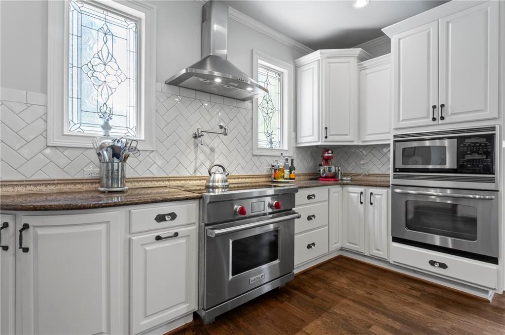285 Old Hornage Road Ball Ground, GA 30107 - Photo 34 of 76 a kitchen with stainless steel appliances granite countertop a stove and white cabinets