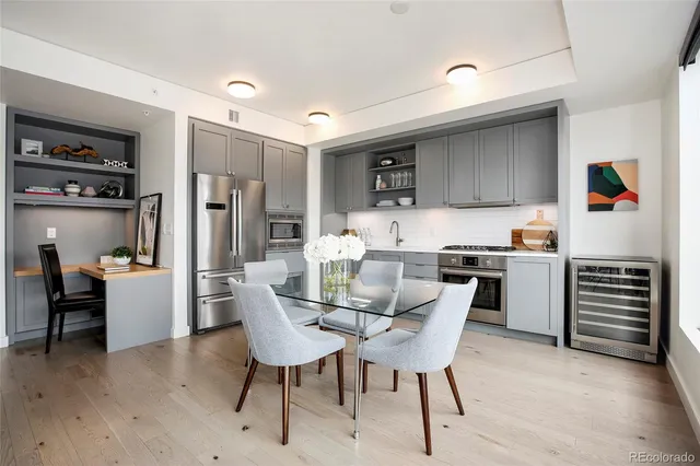 a kitchen with refrigerator and chairs