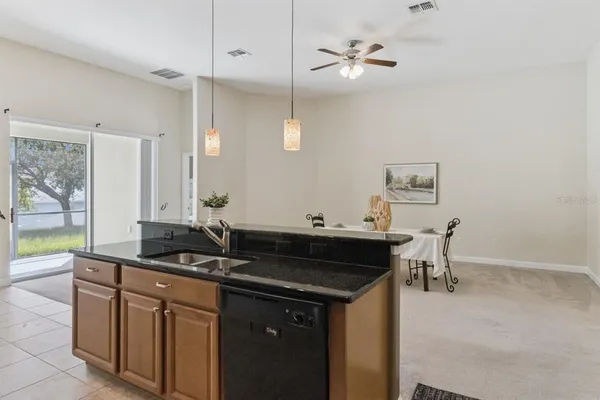 a kitchen that has a sink and a stove with chairs