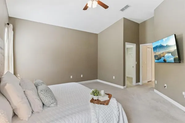 a bedroom with a bed and a painting on the wall