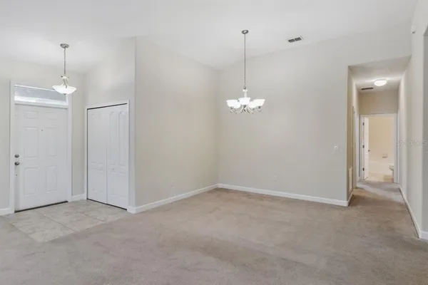 a view of empty room with windows and chandelier