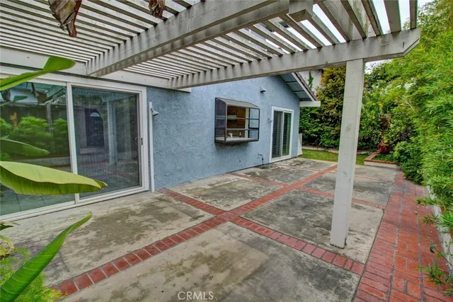 a view of a backyard with potted plants and floor to ceiling window