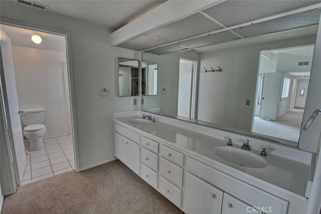 8 Sparrowhawk Irvine, CA 92604 - Photo 44 of 59 a bathroom with a double vanity sink and mirror with toilet