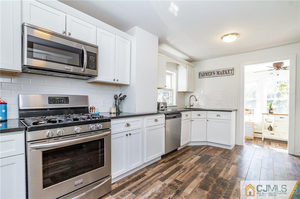 294 E Road Middletown, NJ 07718 - Photo 10 of 23 a kitchen with granite countertop a stove top oven microwave and cabinets