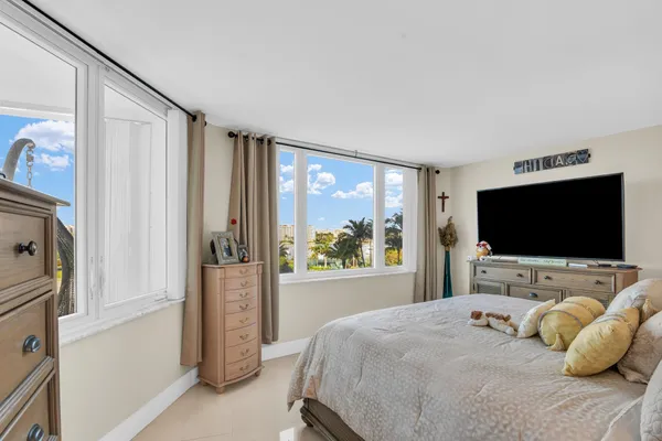 a bedroom with a large bed and a chandelier