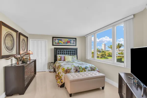 a bedroom with a large window and a flat screen television