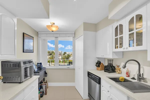 a kitchen with granite countertop a sink appliances and cabinets