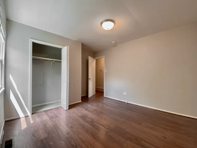 an empty room with wooden floor and closet