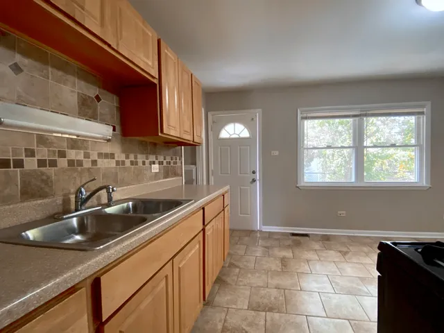 a kitchen with a sink cabinets and window