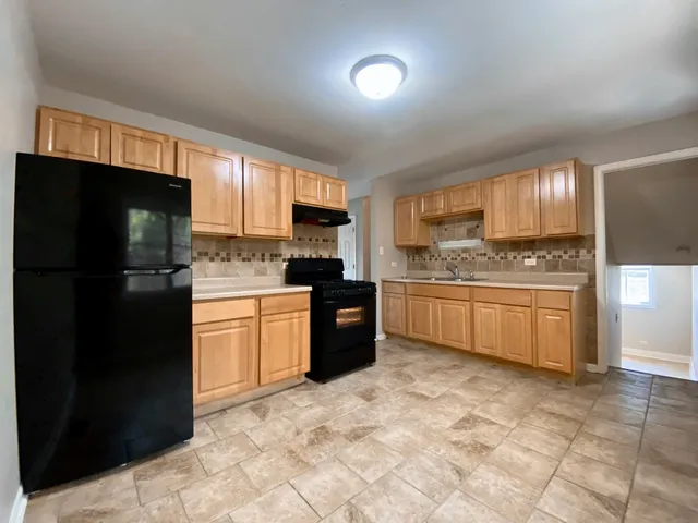 a kitchen with a refrigerator sink and cabinets