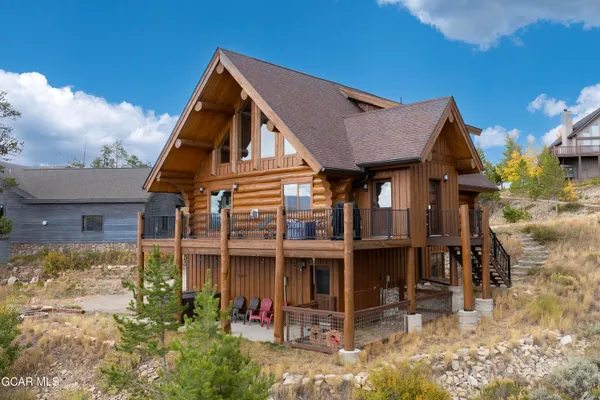 a view of a big house with wooden fence